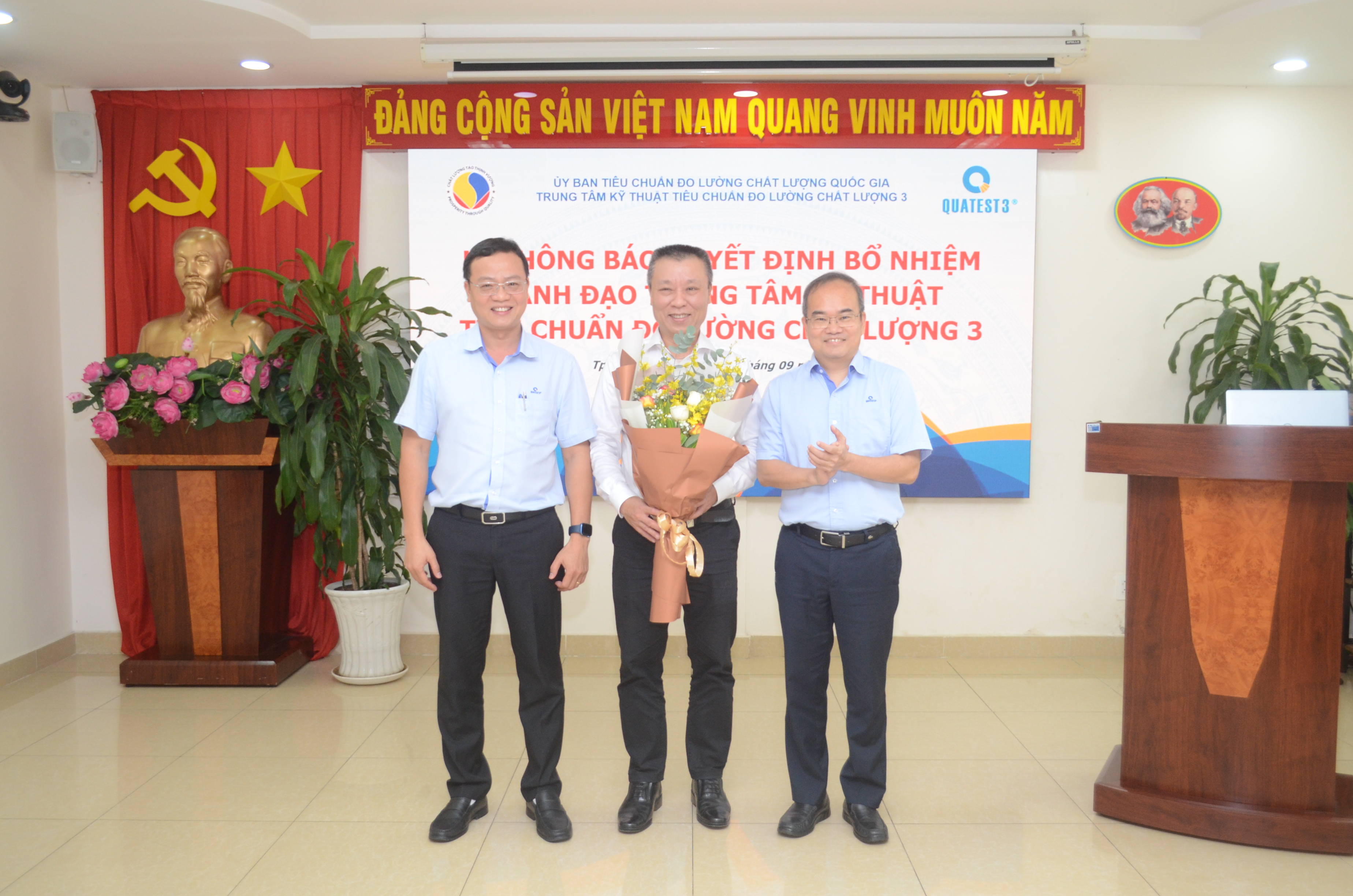 A group of men standing in a room with a podium and a bannerAI-generated content may be incorrect.