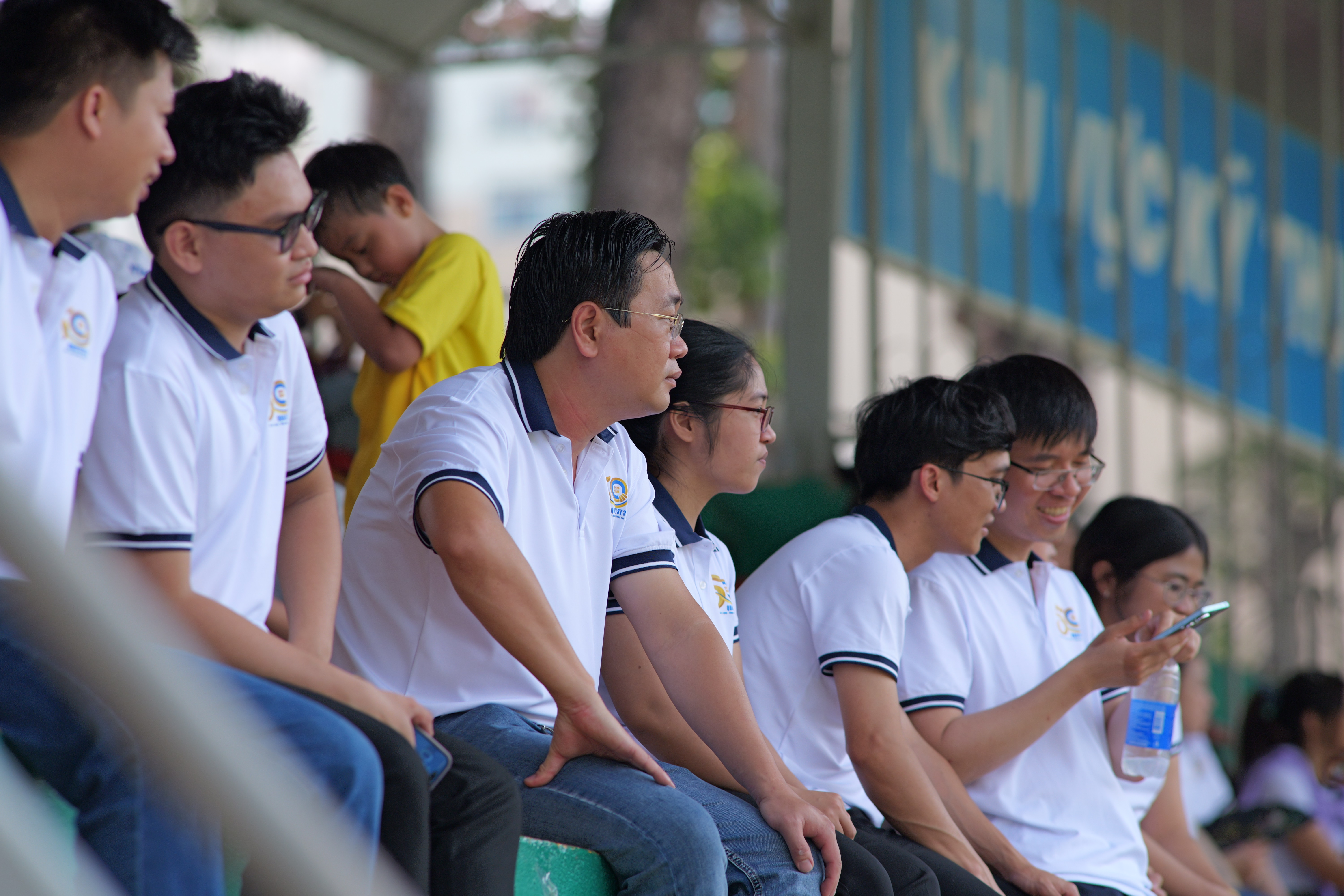 A group of people sitting on a benchAI-generated content may be incorrect.
