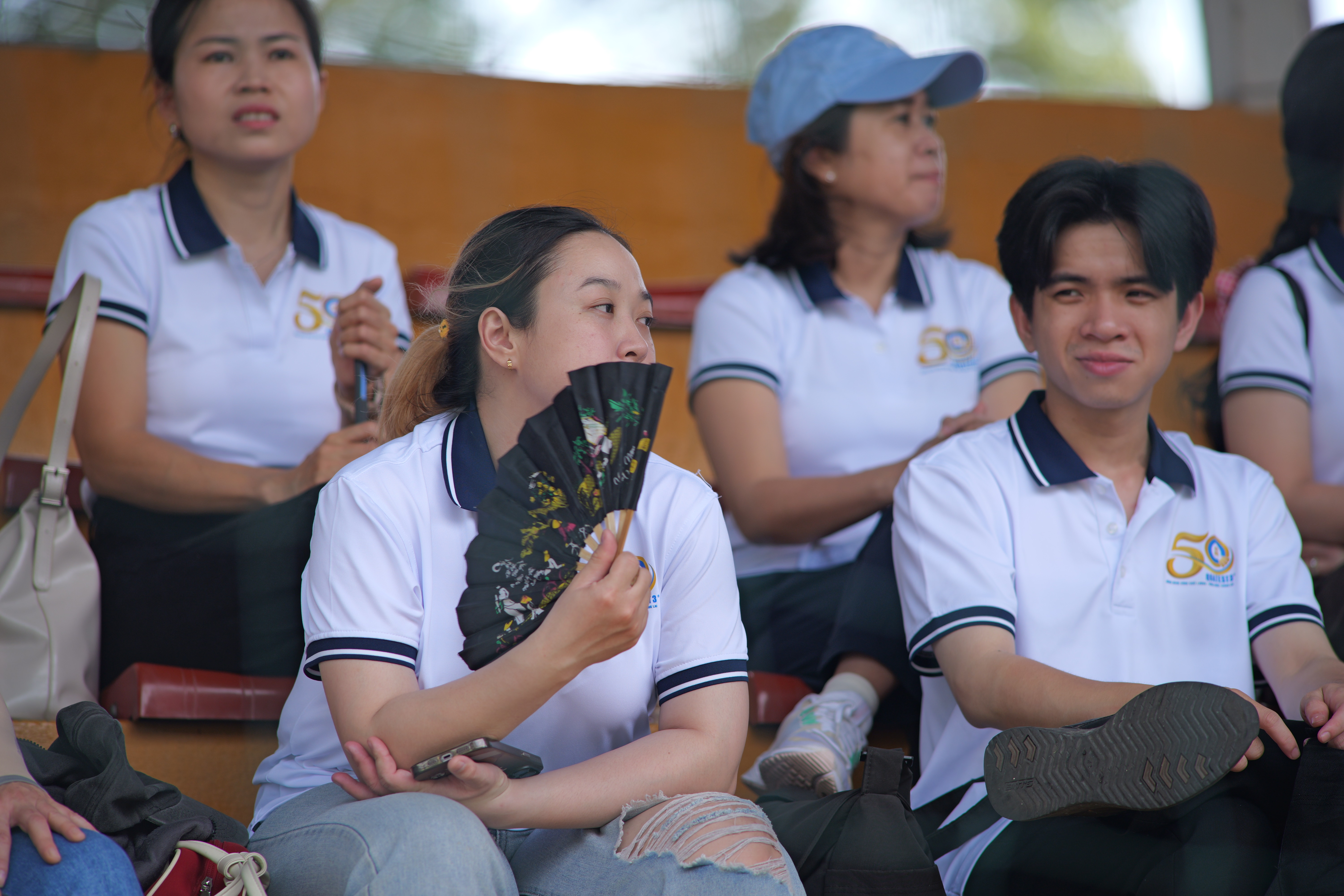A group of people sitting in bleachersAI-generated content may be incorrect.